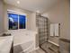 Bright bathroom with bathtub, neutral colors, and modern fixtures with a window at 9412 Burgundy Cir, Highlands Ranch, CO 80126
