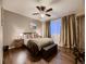 Bedroom with wood floors and a cushioned storage bench at the foot of the bed at 9412 Burgundy Cir, Highlands Ranch, CO 80126