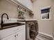 Functional laundry room with modern washer and dryer, storage cabinets, and countertop space at 9412 Burgundy Cir, Highlands Ranch, CO 80126