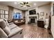 Cozy living room boasts a fireplace, large windows, plush seating, and hardwood floors at 9412 Burgundy Cir, Highlands Ranch, CO 80126