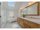 Bright bathroom featuring a soaking tub, glass-enclosed shower, and double vanity at 2340 S Columbine St, Denver, CO 80210