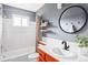 Bathroom features a tub, bright white tile, updated vanity and modern fixtures at 5190 E Asbury Ave, Denver, CO 80222