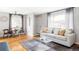 Cozy living room featuring hardwood floors, stylish sofa, and bright natural light from a large window at 5190 E Asbury Ave, Denver, CO 80222