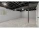 Finished basement with painted brick wall and black ceiling and support at 1248 Meadow St, Longmont, CO 80501