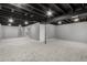 Finished basement with gray brick accent wall, black ceiling, and soft gray carpet at 1248 Meadow St, Longmont, CO 80501