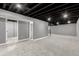 Spacious basement with gray walls and carpet, black ceiling, and finished storage and bathroom entrances at 1248 Meadow St, Longmont, CO 80501