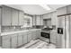 Well-lit kitchen with gray cabinets, stainless steel appliances, gray backsplash and hardwood floors at 1248 Meadow St, Longmont, CO 80501