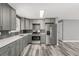 Well-lit kitchen with gray cabinets, stainless steel appliances, gray backsplash and hardwood floors at 1248 Meadow St, Longmont, CO 80501