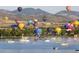 Aerial view of a lake with hot air balloons and boats, offering stunning mountain views at 8367 S Reed St # A1, Littleton, CO 80128