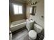 Bathroom featuring a tub with tile surround, sleek vanity, and modern fixtures for a fresh feel at 2625 W Ellsworth Ave, Denver, CO 80219
