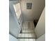 Staircase leading down with white tiled steps and a door with a window at 2625 W Ellsworth Ave, Denver, CO 80219