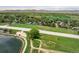 An aerial view captures a neighborhood with lush trees, water features and mountain views at 2117 Stonehenge Cir, Lafayette, CO 80026