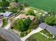 An aerial shot showcases the home's lush green landscaping, long driveway, and proximity to neighboring houses and greenery at 2117 Stonehenge Cir, Lafayette, CO 80026