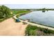 An aerial view showcases a serene lake with a sandy beach and walking trails at 2117 Stonehenge Cir, Lafayette, CO 80026