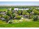 Aerial view featuring a pond, a variety of houses with mature trees, and green fields at 2117 Stonehenge Cir, Lafayette, CO 80026