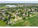 Aerial view of the neighborhood and houses with landscaping and a large pond at 2117 Stonehenge Cir, Lafayette, CO 80026