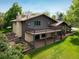 A large wooden deck overlooks the spacious backyard with well-maintained lawn and mature landscaping at 2117 Stonehenge Cir, Lafayette, CO 80026