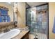 Rustic bathroom featuring stone countertops, a vessel sink, a tiled shower, and decorative wooden accents at 2117 Stonehenge Cir, Lafayette, CO 80026