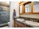 Bathroom featuring a double sink vanity with tiled backsplash and glass enclosed shower at 2117 Stonehenge Cir, Lafayette, CO 80026