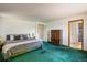 Large bedroom featuring green carpet and multiple closets and doorways at 2117 Stonehenge Cir, Lafayette, CO 80026