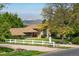 Charming home exterior featuring a white fence, lush lawn, and mountain views in the background at 2117 Stonehenge Cir, Lafayette, CO 80026