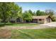 Charming brick home featuring a large front yard with mature trees and well-maintained landscaping at 2117 Stonehenge Cir, Lafayette, CO 80026