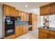 Kitchen boasts wooden cabinetry, a built-in oven, microwave, and a view of the staircase at 2117 Stonehenge Cir, Lafayette, CO 80026