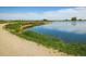 Picturesque lake view featuring a walking path, lush grass and calm reflective water at 2117 Stonehenge Cir, Lafayette, CO 80026
