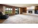 Spacious living room featuring a brick fireplace, wood paneling, and sliding glass door at 2117 Stonehenge Cir, Lafayette, CO 80026