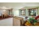 Bright and airy living room flowing into the dining area with large windows showcasing serene outdoor views at 2117 Stonehenge Cir, Lafayette, CO 80026