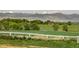 Pastoral scene featuring a white fence, green fields, trees and picturesque views of the mountains in the background at 2117 Stonehenge Cir, Lafayette, CO 80026
