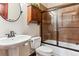 Clean bathroom with a shower/tub combo, pedestal sink, and wood cabinet at 7205 Fallon Cir, Castle Rock, CO 80104