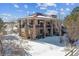 Two-story home with balcony, stone exterior, and snowy backyard at 7205 Fallon Cir, Castle Rock, CO 80104