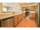 Well-lit kitchen features stainless steel appliances, wood cabinets, and wood floors at 6407 S Dallas Ct, Englewood, CO 80111