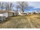 Expansive backyard featuring a detached garage, house, and mature trees at 5300 Balsam St, Arvada, CO 80002
