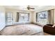 Bright living room featuring a ceiling fan, large windows, and a door to the outside at 5300 Balsam St, Arvada, CO 80002