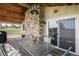 View of the covered deck with a stone fireplace, table and chairs at 1801 Buttercup Rd, Elizabeth, CO 80107