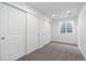 A bedroom featuring carpet floors, two closets, and a window at 6284 N Genoa Way, Aurora, CO 80019