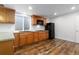 A kitchen featuring wood cabinets, and sleek black appliances on wood-look floors at 6284 N Genoa Way, Aurora, CO 80019