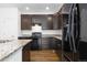 Stylish kitchen with dark wood cabinets, granite counters, and stainless steel appliances at 6284 N Genoa Way, Aurora, CO 80019