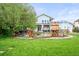 Expansive backyard featuring lush green grass, mature tree, and decorative water tower feature at 2161 Elmwood St, Berthoud, CO 80513