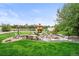 Spacious backyard featuring a unique water fountain, mature trees, and lush green lawn perfect for relaxation at 2161 Elmwood St, Berthoud, CO 80513