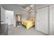 Cozy bedroom featuring plush carpet, a cheerful yellow bedspread, and ample closet space at 2161 Elmwood St, Berthoud, CO 80513