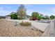 Landscaped front yard with stone pathways, gravel beds, mature trees, and lush greenery enhances curb appeal at 2161 Elmwood St, Berthoud, CO 80513