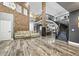 Open-concept living area with hardwood floors, soaring ceilings, brick accents, and modern staircase at 2161 Elmwood St, Berthoud, CO 80513
