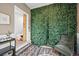 Unique interior space featuring a striking green leaf wall accent and views into an adjacent room at 2161 Elmwood St, Berthoud, CO 80513
