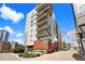 Modern apartment building with multiple balconies and brick accents, set against a blue sky at 1475 Delgany St # 306, Denver, CO 80202