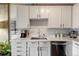 Well-lit kitchen showcasing white cabinets, sleek hardware, and modern appliances on marble countertops at 1475 Delgany St # 306, Denver, CO 80202