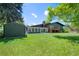 Expansive backyard featuring a lush lawn, storage shed, sunroom, and deck with wooden stairs at 5265 W Quarles Dr, Littleton, CO 80128