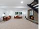 Basement living room with fireplace, neutral carpet, two sofas, and abundant natural light from egress windows at 5265 W Quarles Dr, Littleton, CO 80128